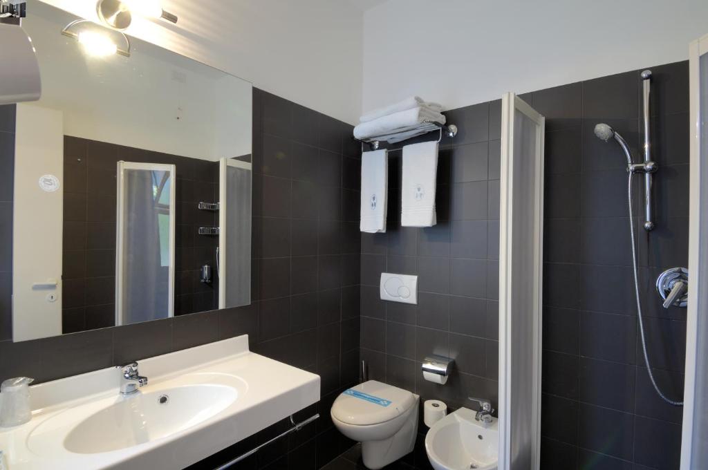 une salle de bain avec un lavabo et des toilettes dans l'établissement Hotel Firenze, à Bibione