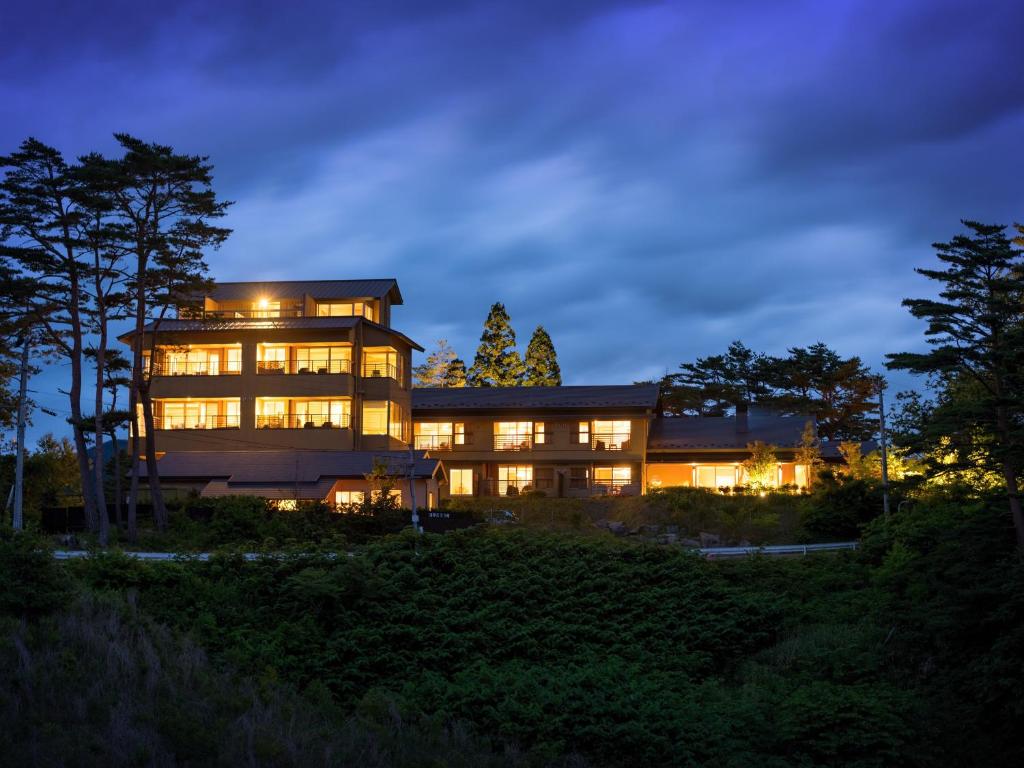 une grande maison éclairée la nuit dans l'établissement Nagisatei Taroan, à Miyako