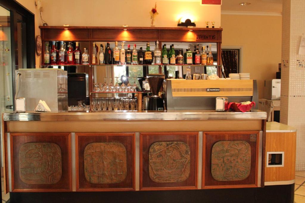 un bar avec beaucoup de bouteilles d'alcool dans l'établissement Hotel Caravel, à Sottomarina