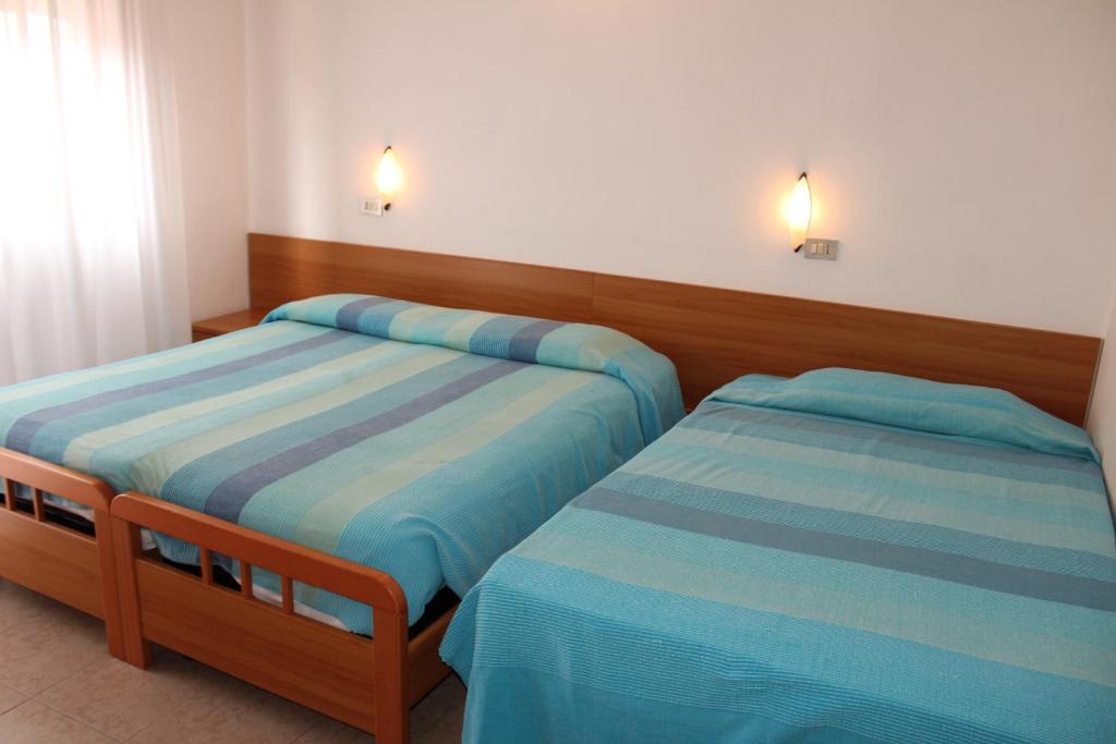 une chambre avec deux lits dans une pièce dans l'établissement Hotel Caravel, à Sottomarina 37 autres photos