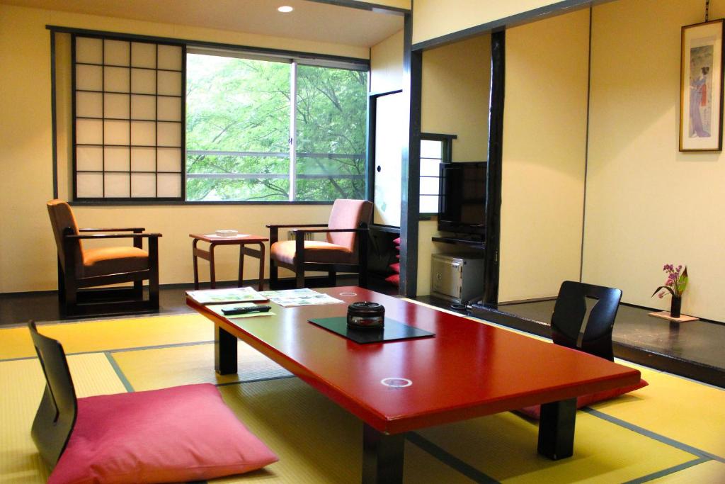 un salon avec une table et des chaises dans l'établissement Shinki, à Shibukawa