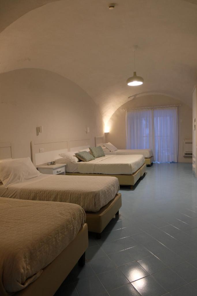 - un groupe de trois lits dans une chambre dans l'établissement Hotel Baia Di Puolo, à Massa Lubrense