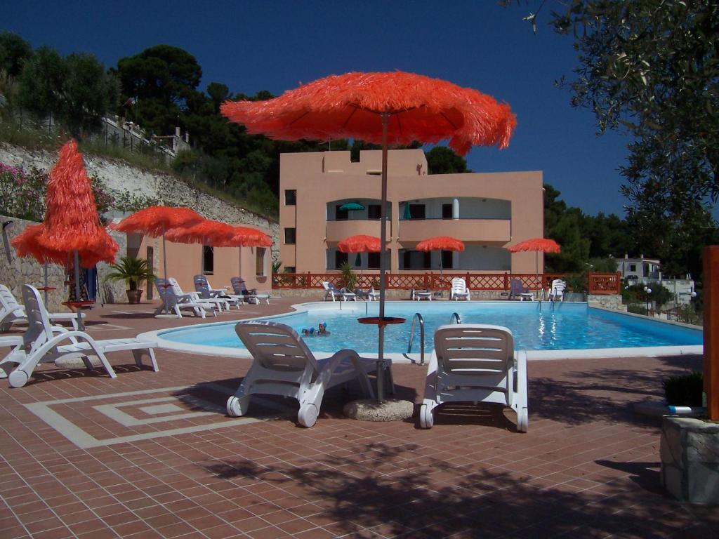 une piscine avec chaises et parasols et une piscine dans l'établissement Villa dei pini, à Vieste