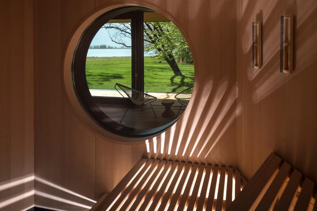 Cette chambre dispose d'une fenêtre et d'un banc avec un miroir. dans l'établissement Seehotel Ambach, à Caldaro 28 autres photos