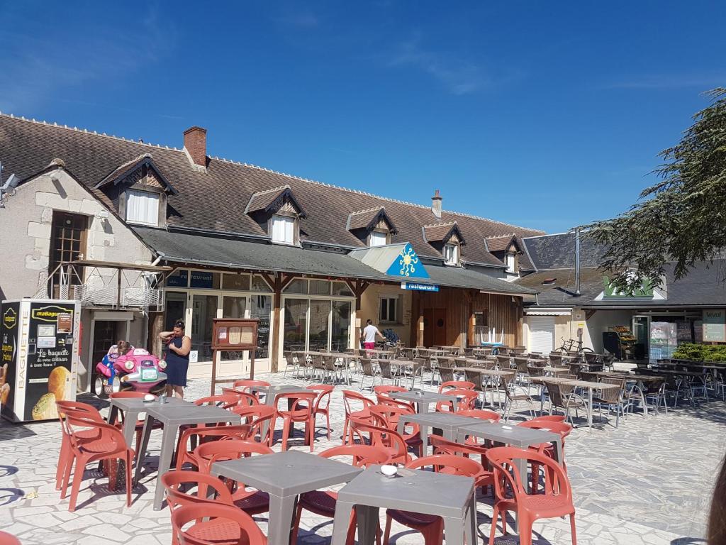 un groupe de tables et de chaises devant un bâtiment dans l'établissement camping onzain 4 etoiles, à Onzain