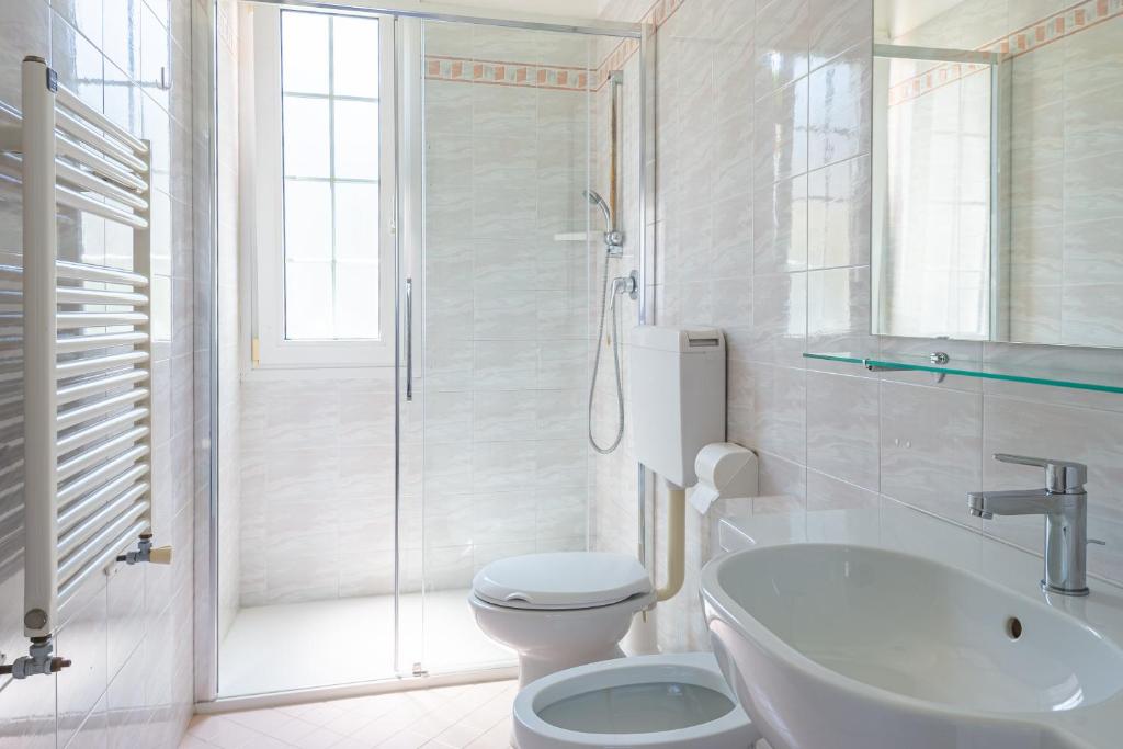 une salle de bain avec toilettes, lavabo et douche dans l'établissement Margherita Family Apartments, à Cavallino-Treporti 25 autres photos