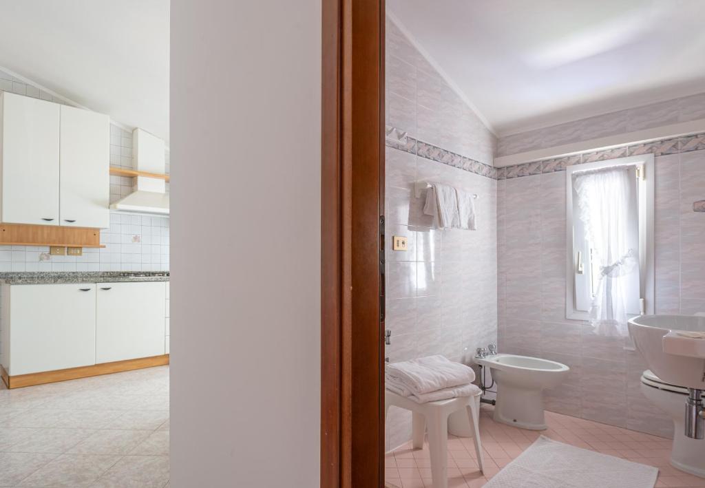 une salle de bain blanche avec un lavabo et des toilettes dans l'établissement Margherita Family Apartments, à Cavallino-Treporti