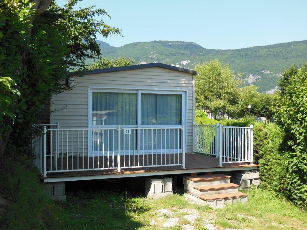 une petite maison avec un porche et une terrasse dans l'établissement CAMPING LE GRAND VERNEY, à Novalaise