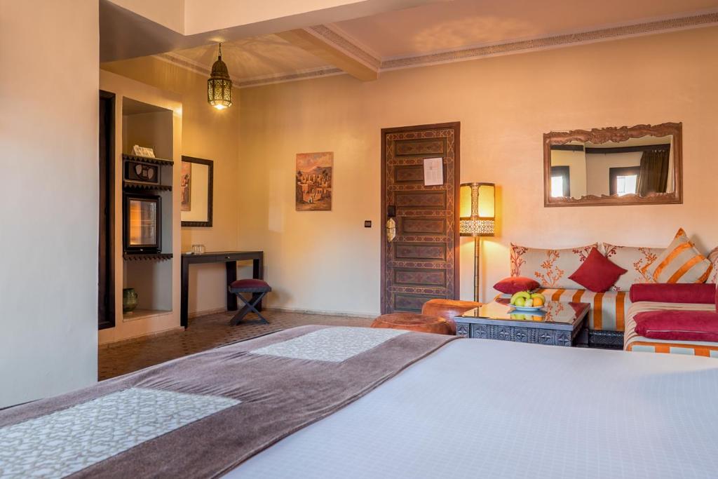 une chambre avec un lit et un salon dans l'établissement Riad Marrakech By Hivernage, à Marrakech