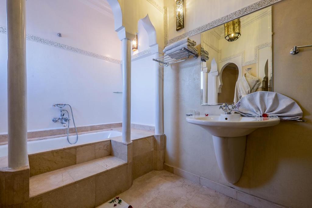 une salle de bain avec un lavabo et une baignoire et un lavabo dans l'établissement Riad Marrakech By Hivernage, à Marrakech