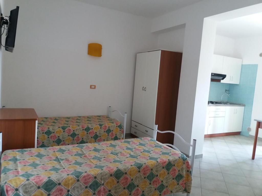 une chambre d'hôtel avec deux lits et une cuisine dans l'établissement Villa dei pini, à Vieste 229 autres photos