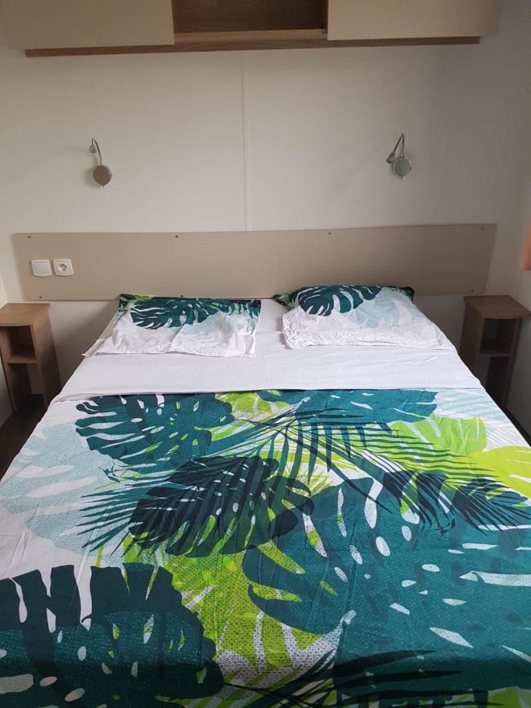 - un lit avec une couette et des oreillers colorés dans l'établissement BVCO LOCATIONS PROCHE CHATEAUX ET BEAUVAL DANS LE LOIR et CHER, à Onzain