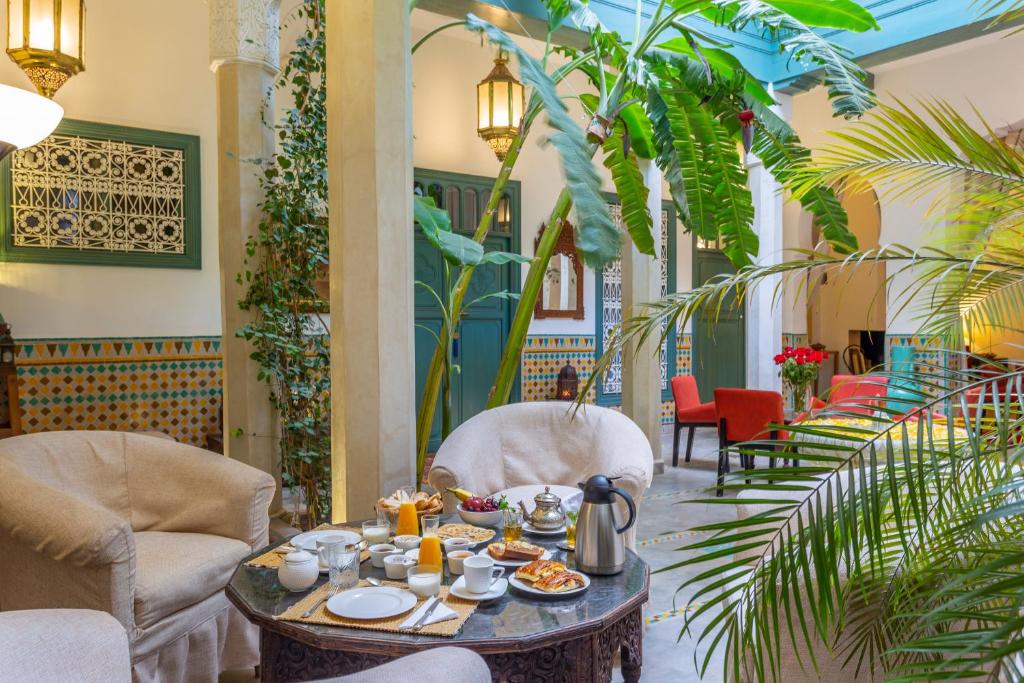 une salle à manger avec une table sur laquelle se trouve de la nourriture dans l'établissement Riad Azahar, à Marrakech