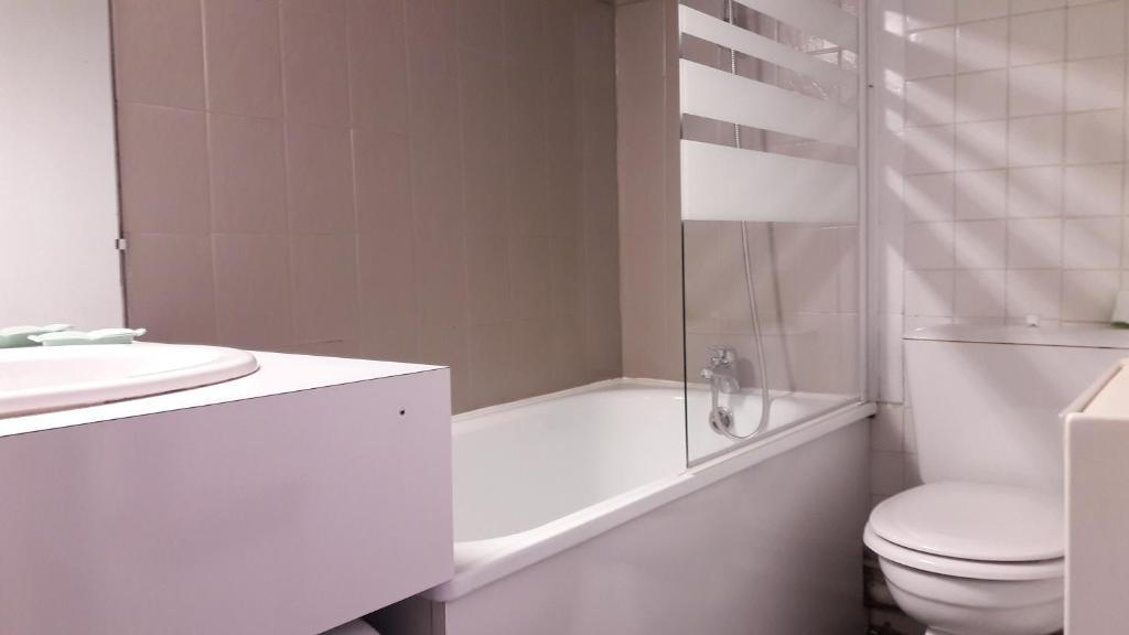 une salle de bain blanche avec des toilettes et un lavabo dans l'établissement Studio au pied des pistes + Cellier, à La Mongie