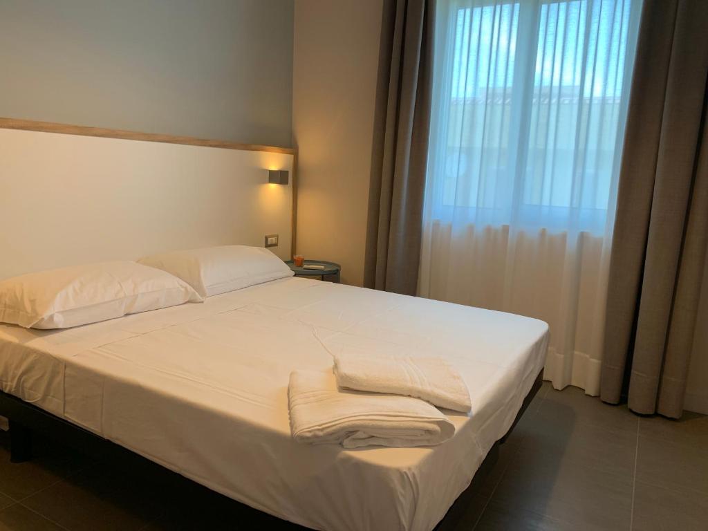 une chambre avec un lit blanc avec des serviettes dessus dans l'établissement RED'S apartments, à Torre Melissa