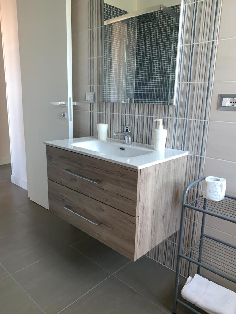 une salle de bain avec un lavabo et un miroir dans l'établissement RED'S apartments, à Torre Melissa