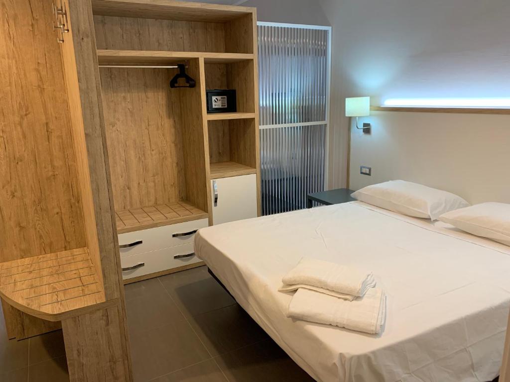 - une chambre avec un lit et un placard en bois dans l'établissement RED'S apartments, à Torre Melissa