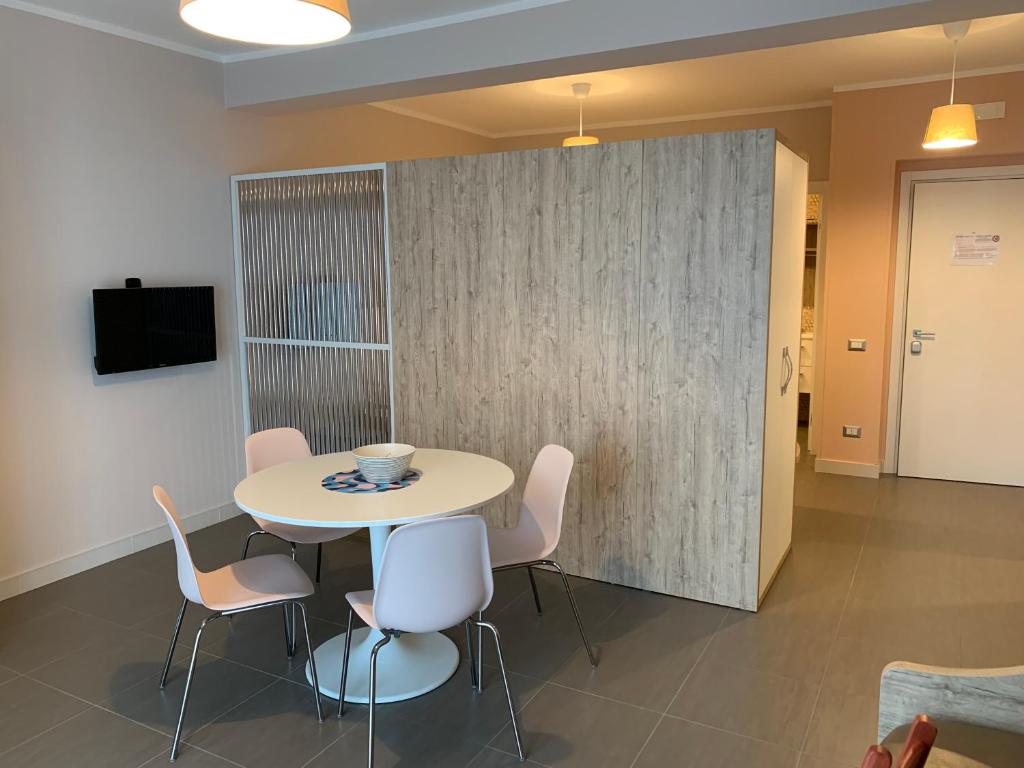 une salle à manger avec une table et des chaises blanches dans l'établissement RED'S apartments, à Torre Melissa