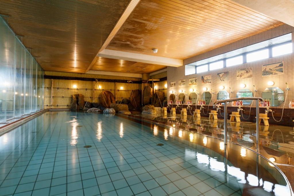 une grande piscine dans un immeuble dans l'établissement Awazuonsen Kitahachi, à Komatsu
