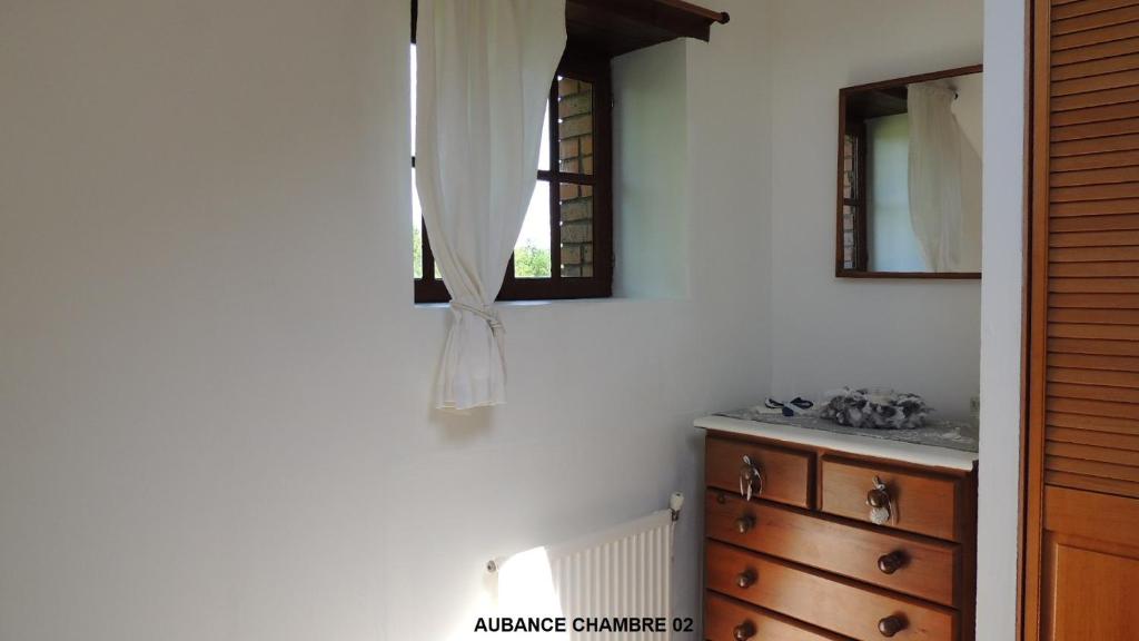 La salle de bains est pourvue d'un lavabo, d'un miroir et d'une commode. dans l'établissement Gîte Aubance 5 Places Moulin de la Placette, à Faye-d'Anjou