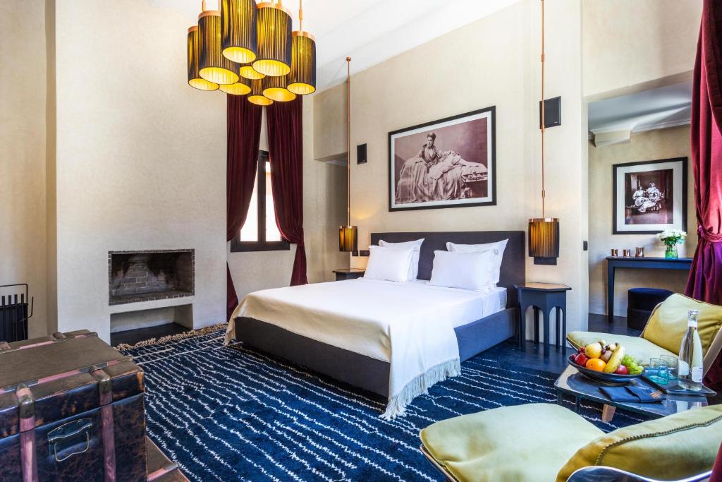 une chambre d'hôtel avec un lit et une cheminée dans l'établissement Riad Tajania, à Marrakech