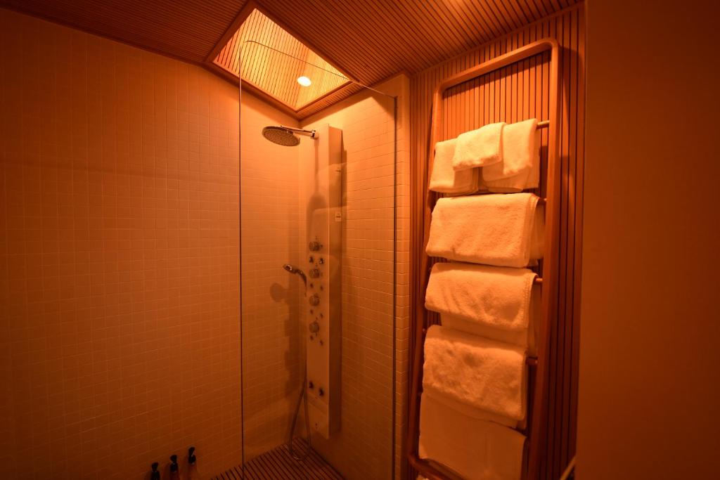 La salle de bains est pourvue d'une douche à l'italienne et de serviettes. dans l'établissement Yado Kiramachi, à Kyoto