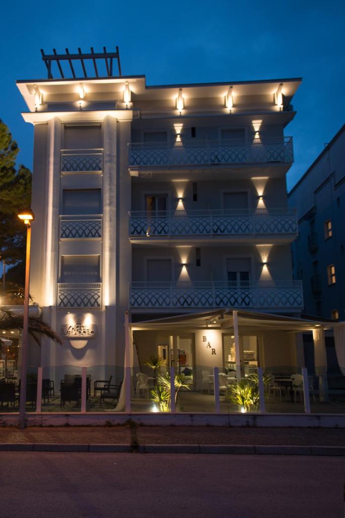 Un grand bâtiment blanc avec des lumières sur lui dans l'établissement Hotel Vela D'Oro, à Riccione