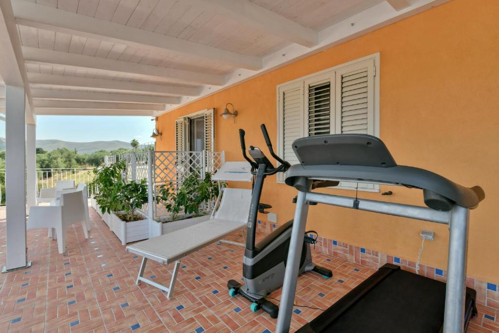 une salle de fitness avec un tapis de course et une table dans l'établissement Hotel Ristorante Colleverde, à Santa Maria di Castellabate