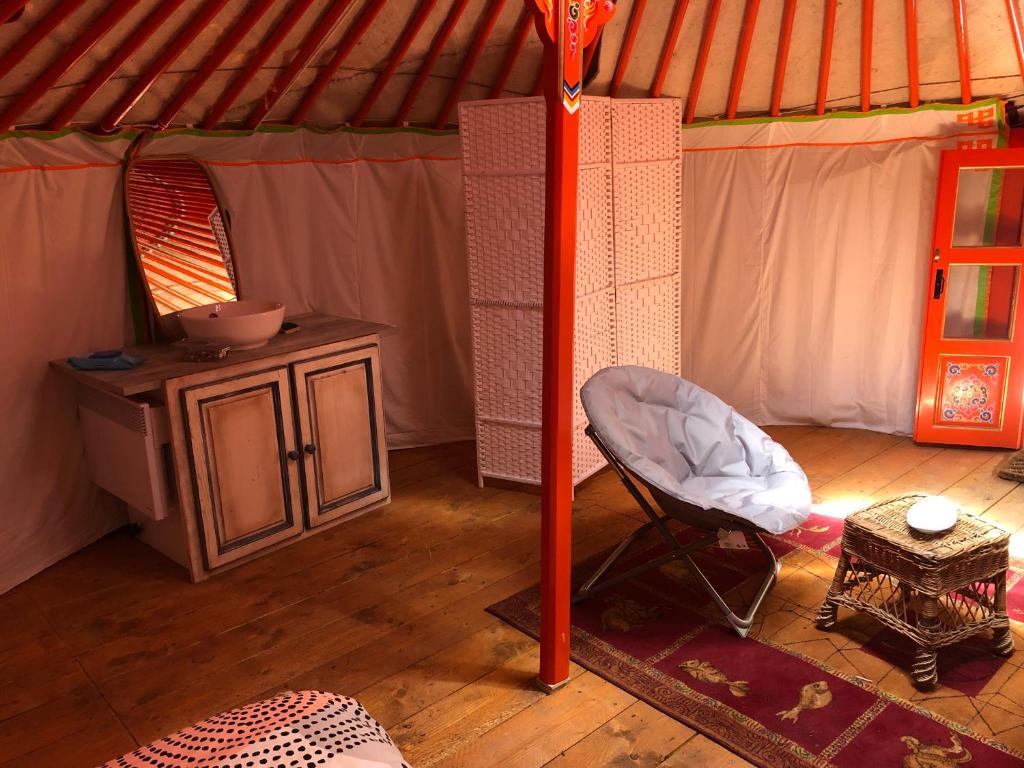 une tente avec une table et une chaise. dans l'établissement Yourte Mongole, à Mont-Roc