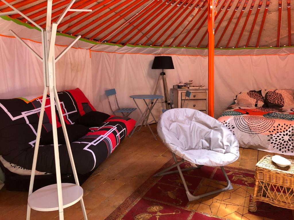Cette chambre comprend une tente avec un lit et une chaise. dans l'établissement Yourte Mongole, à Mont-Roc