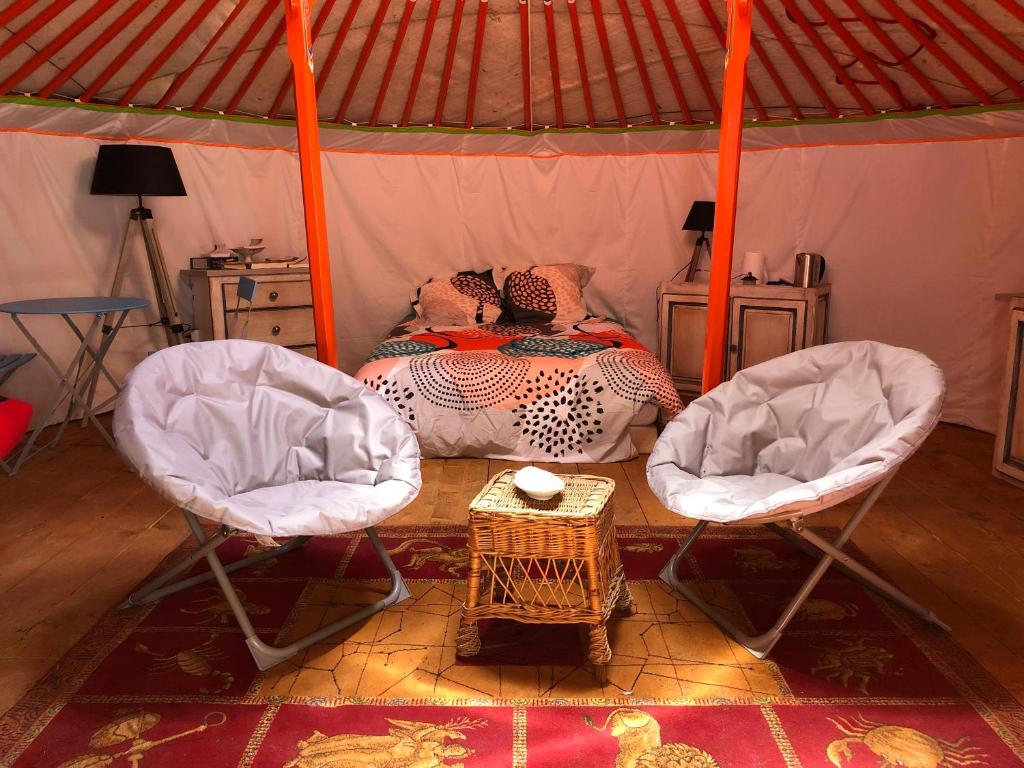 - une chambre avec deux chaises et un lit dans une yourte dans l'établissement Yourte Mongole, à Mont-Roc