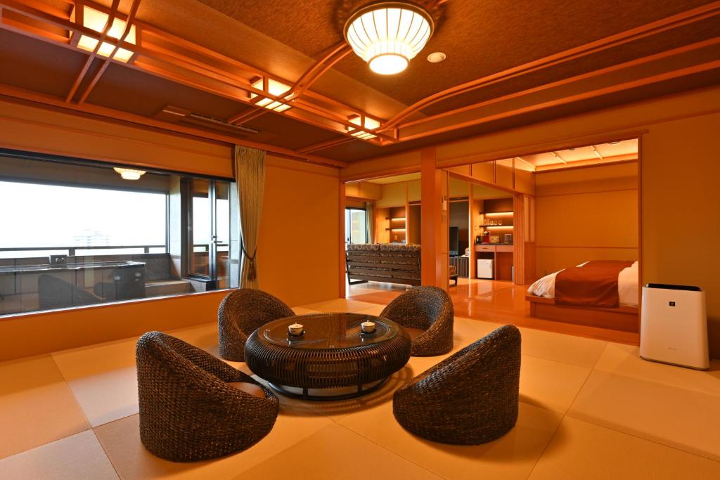 un salon avec une table et des chaises et un lit dans l'établissement Biwako Hanakaido, à Ōtsu