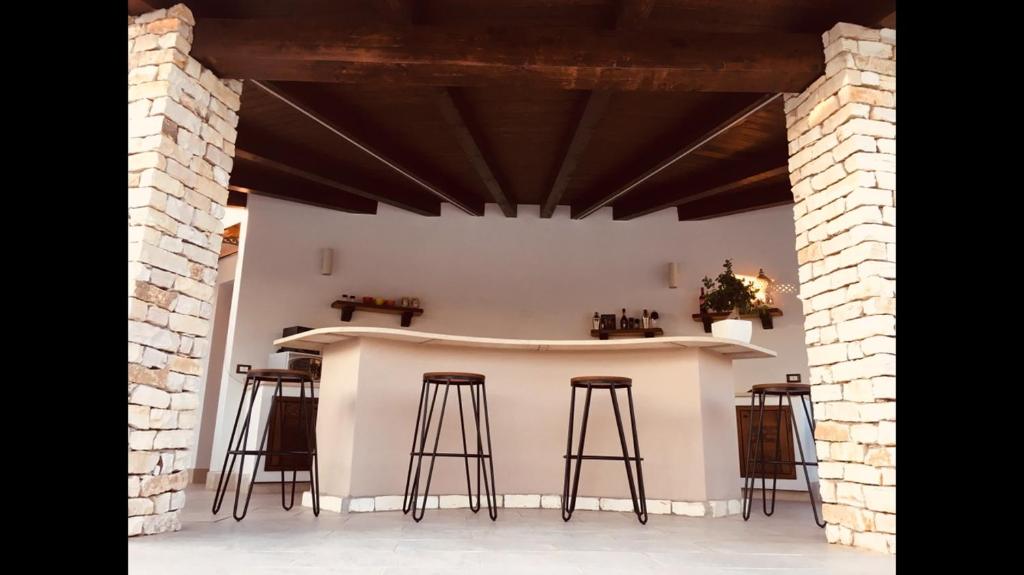 une cuisine avec un comptoir et des tabourets dans une pièce dans l'établissement Villa Araucaria, à Partinico