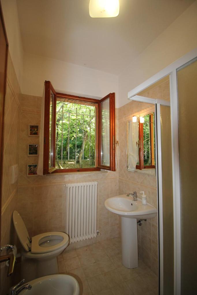 une salle de bain avec un lavabo et des toilettes et une fenêtre dans l'établissement Villa Mombaroccio le colline di Pesaro tra mare e natura, à Mombaroccio