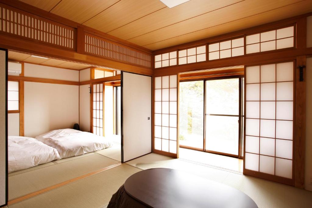 une chambre avec un lit et des fenêtres dans une pièce dans l'établissement Hakone Fura, à Hakone