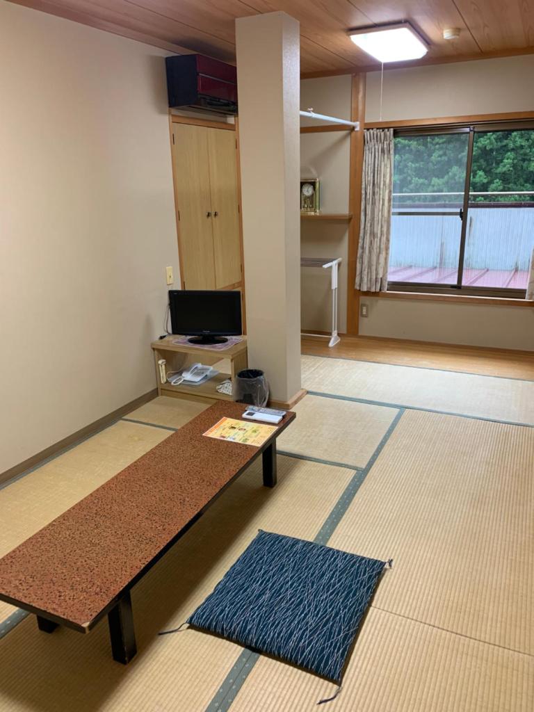 une pièce vide avec une table et un bureau dans l'établissement Minshuku Sumiya, à Tanabe