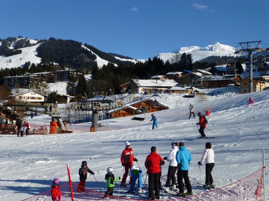 un groupe de personnes debout sur une piste de ski dans l'établissement Chalet Monte-Pente, à Megève