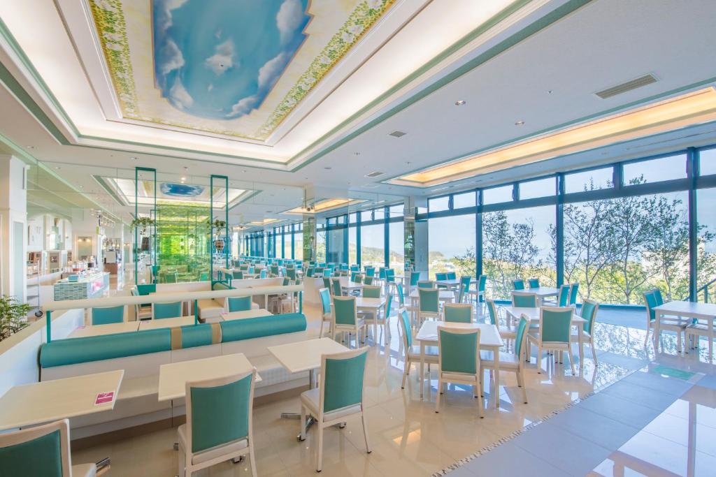 un restaurant avec des tables, des chaises et des fenêtres dans l'établissement Shiretoko Daiichi Hotel, à Shari