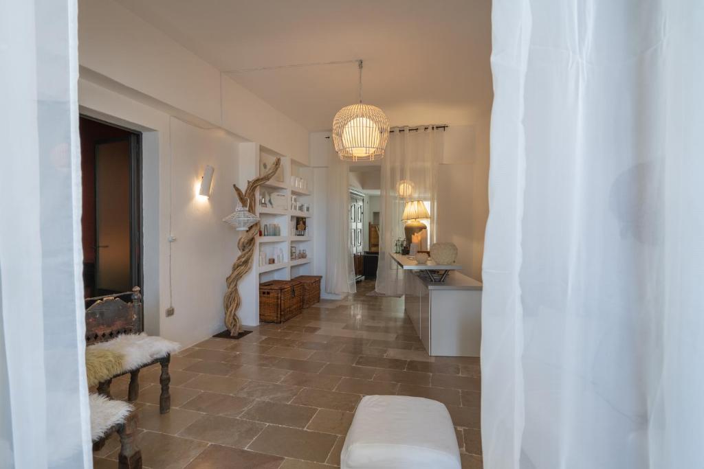 un couloir avec une grande chambre avec une table et un couloir dans l'établissement La Locanda Del Carrubo, à Mattinata