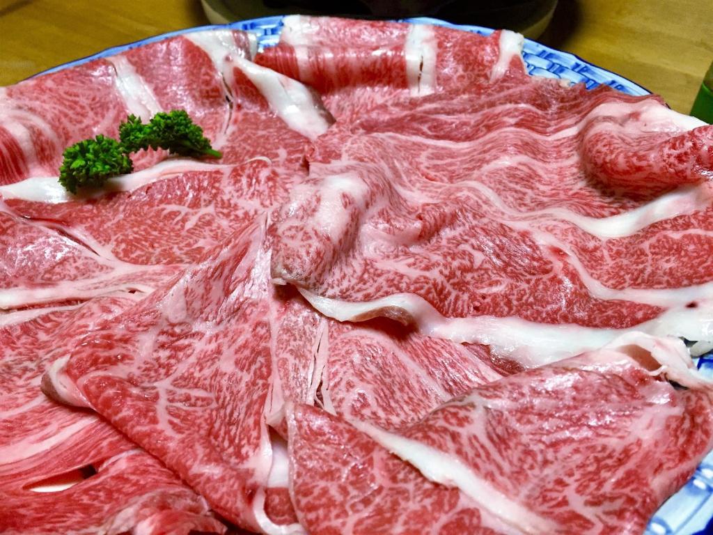 une pile de viande sur une plaque sur une table dans l'établissement Good Stay Mizuho, à Usa 27 autres photos