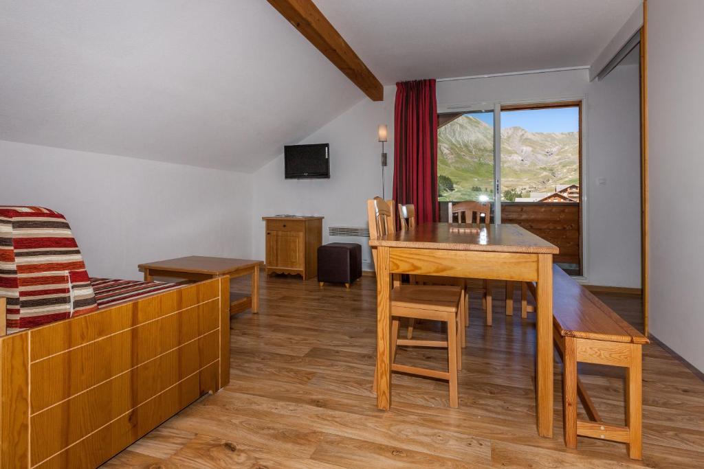 - un salon avec une table à manger et une chambre dans l'établissement Les Cimes Du Val D'Allos, à La Foux