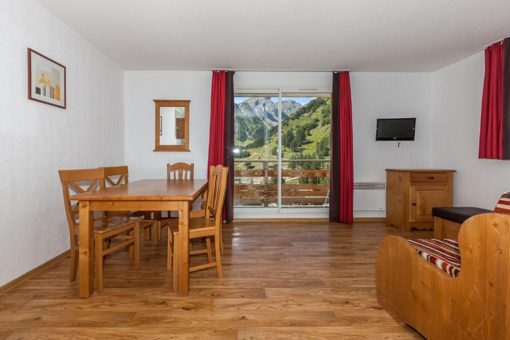 une salle à manger avec une table et un canapé dans l'établissement Les Cimes Du Val D'Allos, à La Foux