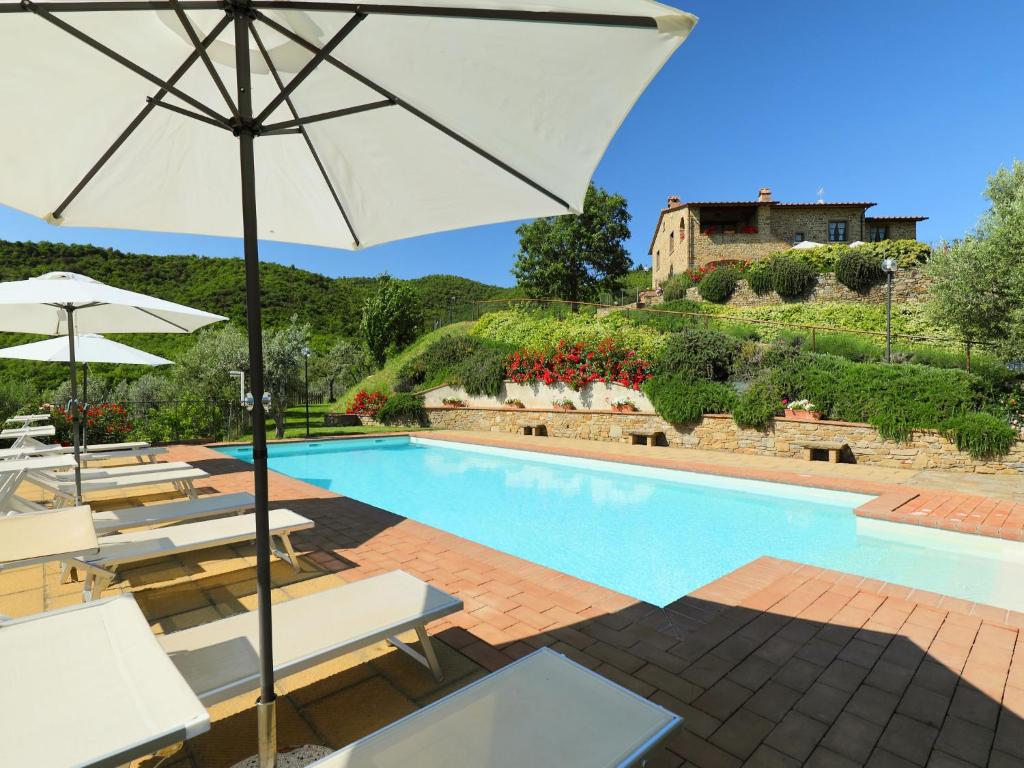 une piscine avec des chaises et un parasol et un bâtiment dans l'établissement Villa Zen by Interhome, à Santa Cristina