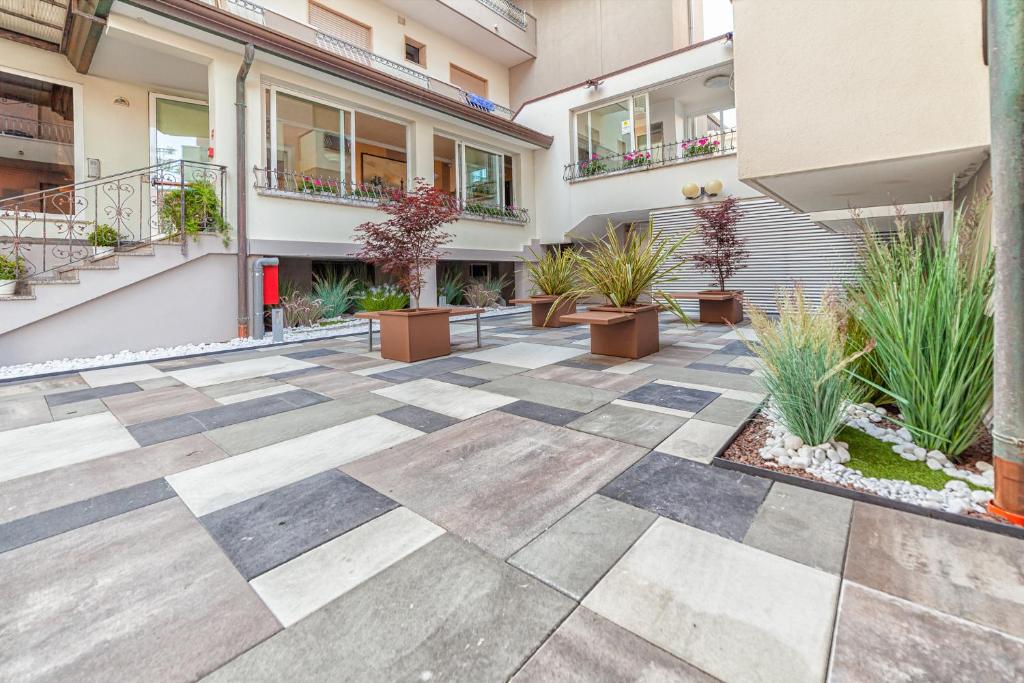 une cour avec des plantes en pot et un bâtiment dans l'établissement Hotel Columbia & Ninfea, à Lido di Jesolo 59 autres photos