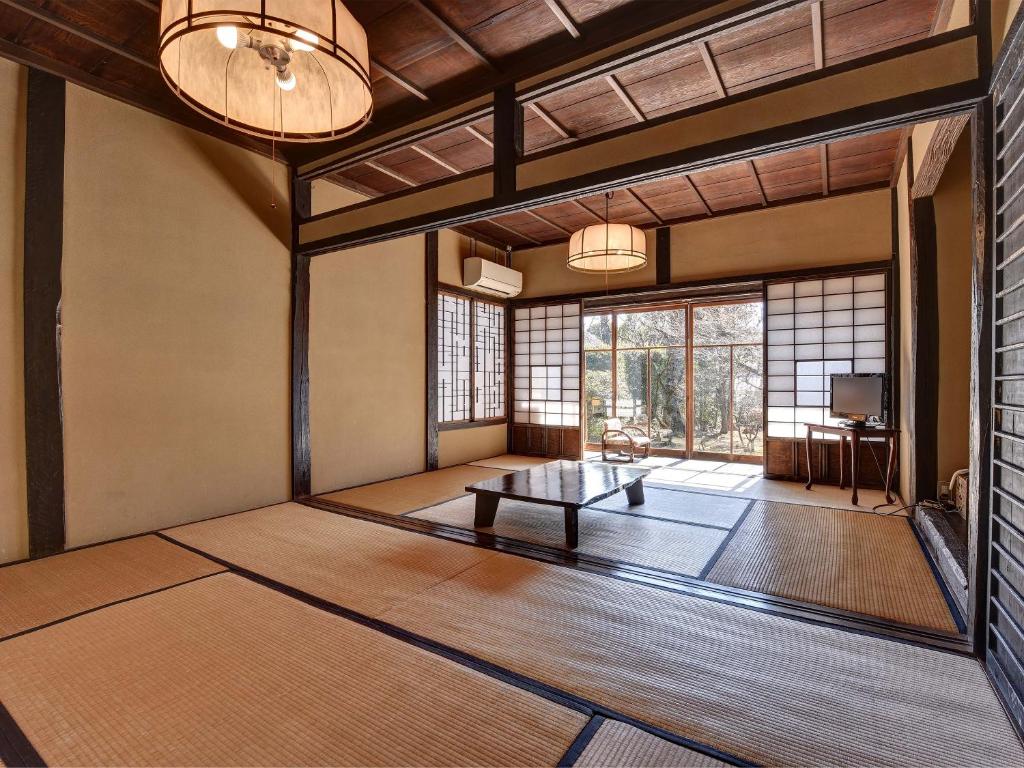 une pièce vide avec une table dans une pièce dotée de fenêtres dans l'établissement Nagataki, à Nakatsugawa