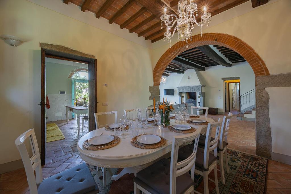 une salle à manger avec une table, des chaises et un lustre dans l'établissement Villa Mezzavia, à Cortone