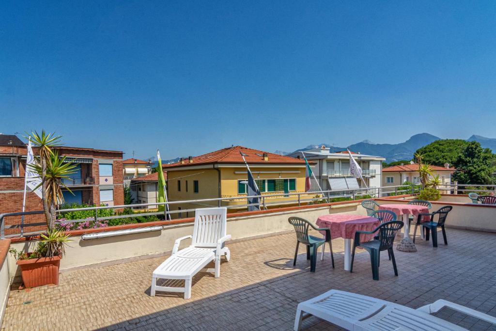 un patio avec tables et chaises sur un toit dans l'établissement Hotel Mariani, à Lido di Camaiore