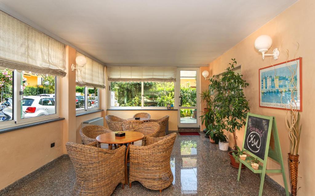une chambre avec des chaises, une table et des fenêtres dans l'établissement Hotel Mariani, à Lido di Camaiore