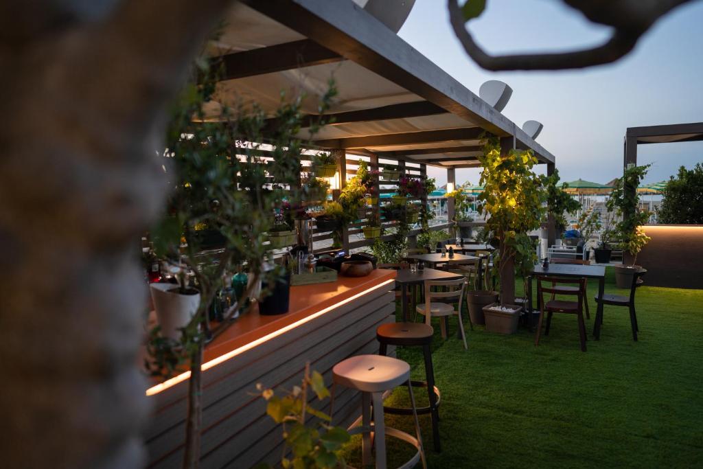 un patio avec des tables, des chaises et des plantes en pot dans l'établissement Hotel Salus, à Pescara