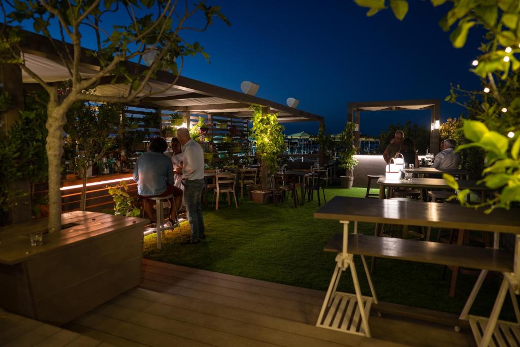 un groupe de personnes assises sur une terrasse la nuit dans l'établissement Hotel Salus, à Pescara 49 autres photos
